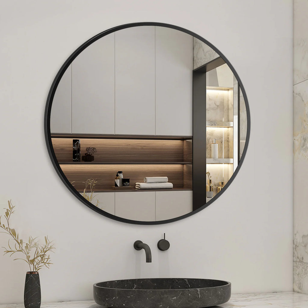 Round black-framed mirror in a modern bathroom with a sink and decorative elements.
