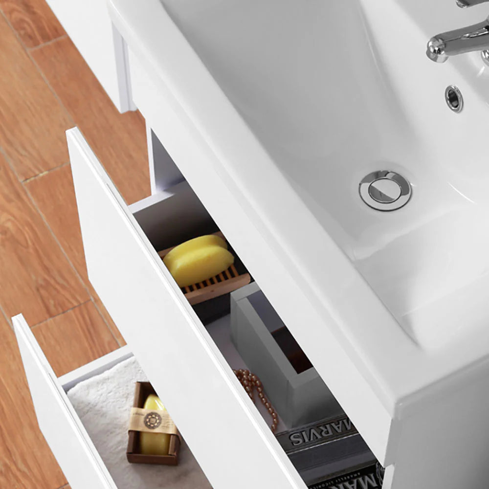 White floating vanity unit with soft close drawers open showing internal storage compartments and bathroom accessories
