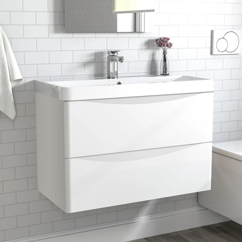 White bathroom vanity with sink against a tiled wall