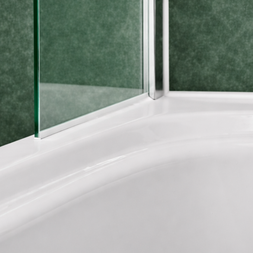 Close-up of bath shower screen with chrome wall profile, clear glass and white bath against green tiled wall