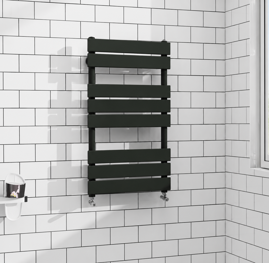 Black flat panel heated towel rail radiator fitted against white brick tiles with black grout in modern bathroom