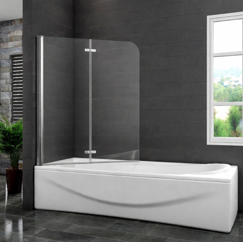 Curved chrome pivot bath screen installed on white bath with dark grey tiled walls and window in modern bathroom setting