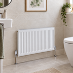 K Rad Type 21 white 1100mm horizontal radiator fitted in a modern downstairs toilet with beige wall tiles, chrome valves and matching tiled flooring.