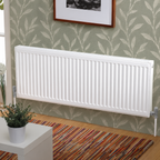 K Rad Type 21 white central heating radiator, 1600mm wide, wall mounted against modern sage green botanical wallpaper with wooden flooring.
