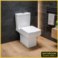 Square close coupled toilet with soft close seat in modern bathroom with black slate wall and oak flooring