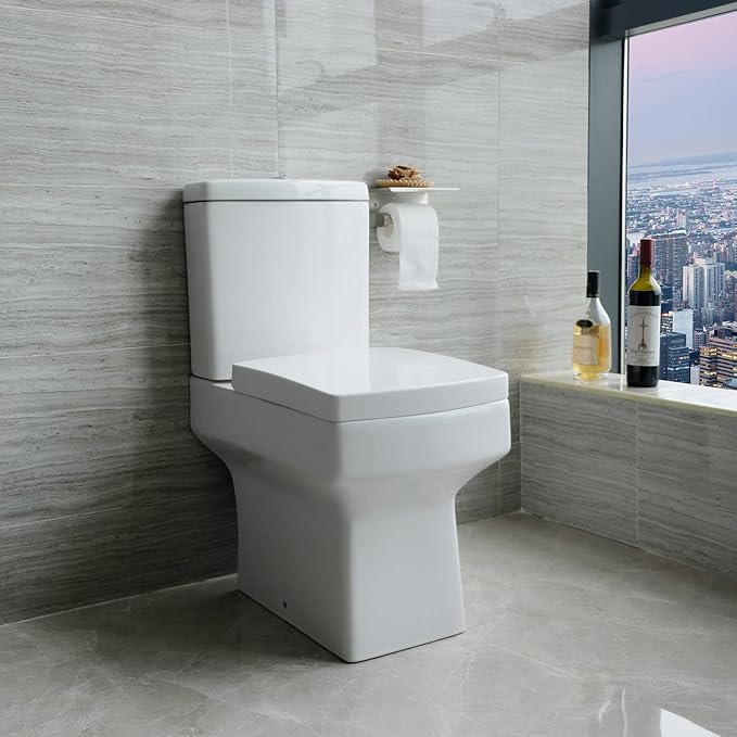 Square close coupled toilet in modern tiled bathroom with window view and wall mounted toilet roll holder