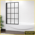 Black grid framed folding bath shower screen installed on bathtub in modern white tiled bathroom
