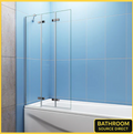 Chrome pivot sliding bath shower screen with clear glass panels fitted to bath against blue tiled wall