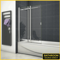 Chrome framed sliding bath shower screen installed on bathtub in modern bathroom with dark tiles