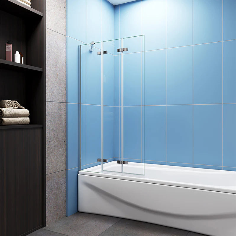 Chrome pivot sliding bath shower screen with clear glass panels installed on bath in modern blue tiled bathroom with shelving unit