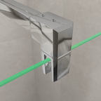 A polished chrome glass shower or sink corner bracket with a green laser overlay showing the alignment of the glass edge and bracket.